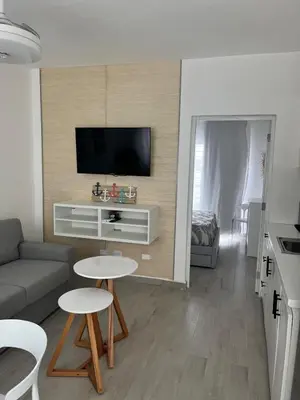 a living room with a couch and a tv at LA CASITA de Bayahibe in Bayahibe
