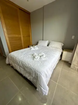 a bed with white sheets and candles on it at Apartamento Santo Domingo este in Juan López