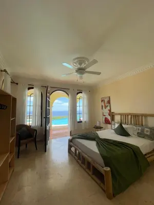 a bedroom with a bed and a ceiling fan at Desconéctate de la civilización in Nagua