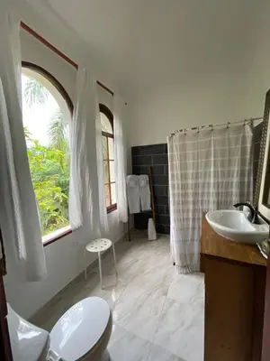 a bathroom with a sink and a toilet and a window at Desconéctate de la civilización in Nagua