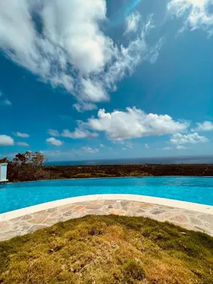 an empty swimming pool with a blue sky and clouds at Desconéctate de la civilización in Nagua