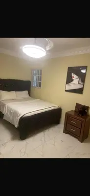 a bedroom with a large bed and a night stand at The Garcias Village C with Jacuzzi ACNetflix in La Alianza
