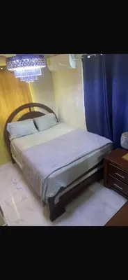 a bedroom with a bed with a blue curtain at The Garcias Village C with Jacuzzi ACNetflix in La Alianza