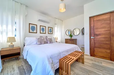 a bedroom with a large bed with a wooden door at Cana Brava Residences Rental Apartment Punta Cana in Punta Cana