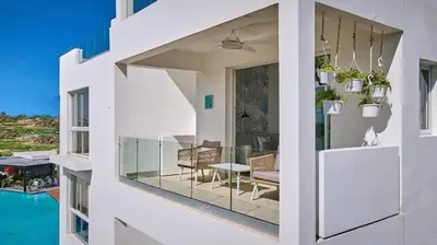 a white house with a view of a dining room at Cana Brava Residences Rental Apartment Punta Cana in Punta Cana