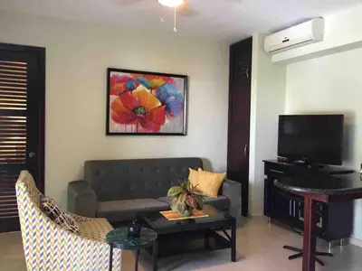 a living room with a couch and a table at Infiniti blu beautiful apartment at the pool in Sosúa