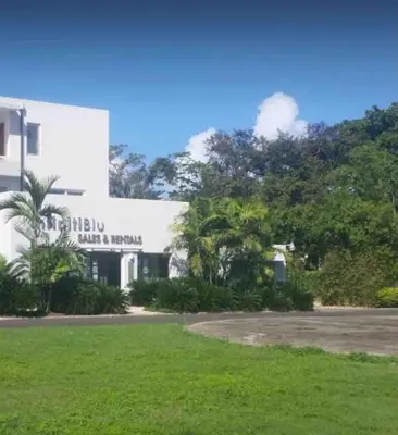 a white building with a sign on the side of it at Infiniti blu beautiful apartment at the pool in Sosúa