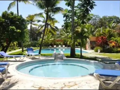 a pool with chairs and a swimming pool at Infiniti blu beautiful apartment at the pool in Sosúa