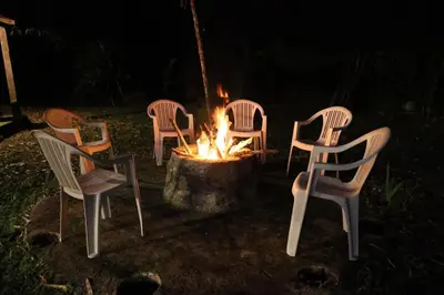 a group of chairs around a fire pit at night at Villa Claudia Constanza in Arroyo Frío
