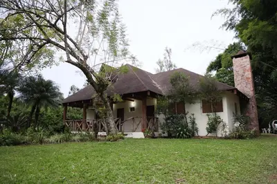 a white house with a tree in the yard at Villa Claudia Constanza in Arroyo Frío