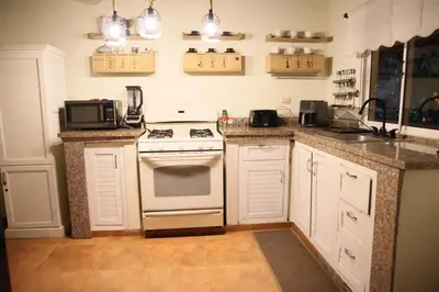 a kitchen with a white stove and a sink at Villa Claudia Constanza in Arroyo Frío