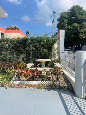 a garden with a bench and flowers next to a fence at Your best escape in Dominican Republic!! in Santiago de los Caballeros