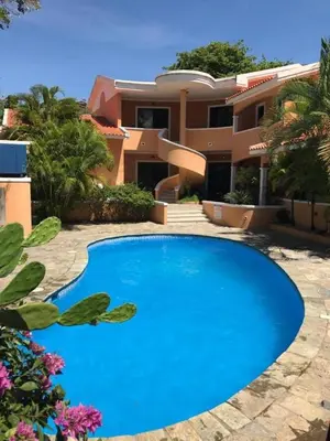 a large blue swimming pool in front of a house at Residence Oasis BocachiCa in Boca Chica