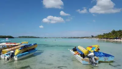 a group of boats in the water on a beach at Residence Oasis BocachiCa in Boca Chica
