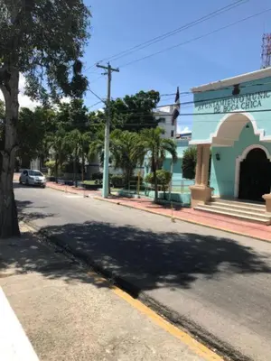 an empty street with a tree and a blue building at Residence Oasis BocachiCa in Boca Chica