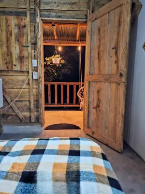 a bedroom with an open wooden door with a bed at Cabañas en las Montañas in San Cristóbal
