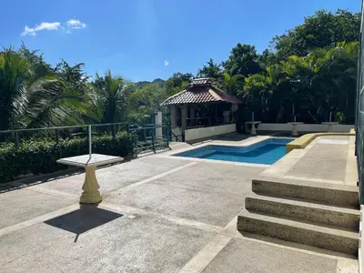 a swimming pool with a bench and a gazebo at La Cigua in Pedro Brand