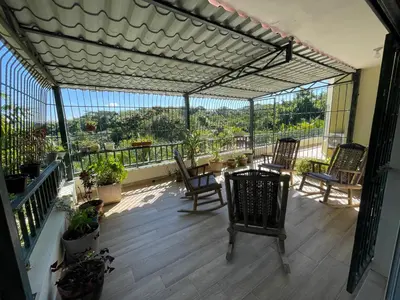 a patio with chairs and a table on a balcony at La Cigua in Pedro Brand