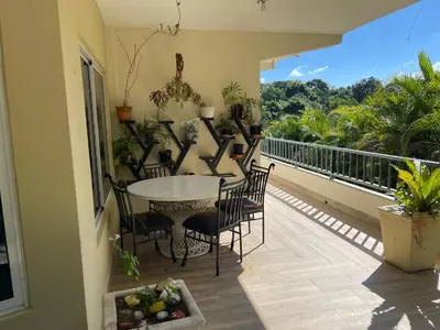 a porch with a table and chairs on a balcony at La Cigua in Pedro Brand
