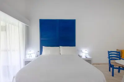 a bedroom with a large bed with a blue headboard at Viva V Samana by Wyndham, A Trademark Adults All Inclusive in Las Terrenas