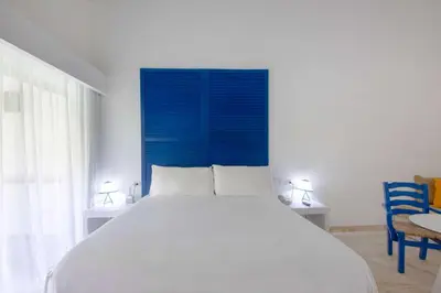 a bedroom with a large bed with a blue headboard at Viva V Samana by Wyndham, A Trademark Adults All Inclusive in Las Terrenas