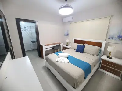 a bedroom with a large bed with a blue blanket at Lujoso exclusivo próximo monumento in Santiago de los Caballeros