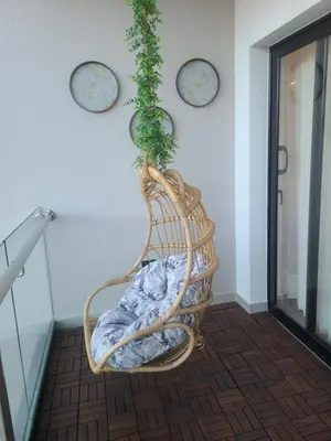 a wicker rocking chair with a plant on the wall at Lujoso exclusivo próximo monumento in Santiago de los Caballeros