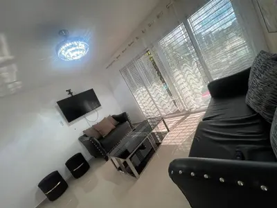 a living room with a couch and a tv at Apartment in Harmony I in Santiago de los Caballeros