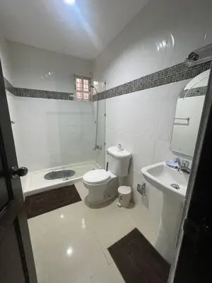 a white bathroom with a toilet and a sink at Apartment in Harmony I in Santiago de los Caballeros