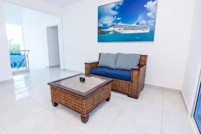 a living room with a wicker chair and a coffee table at Beautiful ocean and mountain view villa in Gaspar Hernández