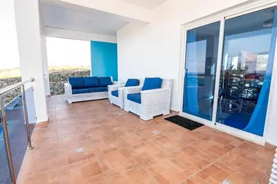 a living room with two chairs and a balcony at Beautiful ocean and mountain view villa in Gaspar Hernández