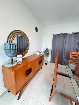 a room with a wooden dresser with a mirror and a chair at Beautiful ocean and mountain view villa in Gaspar Hernández