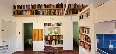 a room with several shelves filled with books at Villa Jardín Tropical in Las Galeras