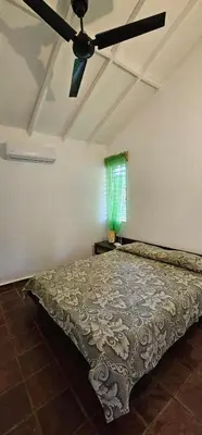 a bedroom with a bed with a ceiling fan at Villa Jardín Tropical in Las Galeras