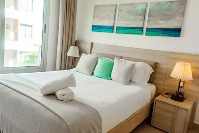 a bedroom with a white bed with a window at Punta cana apparment close to the beach in Punta Cana