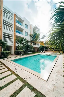 a swimming pool in front of a building at Punta cana apparment close to the beach in Punta Cana