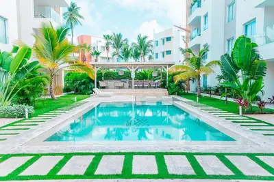 a swimming pool in front of a building at Punta cana apparment close to the beach in Punta Cana