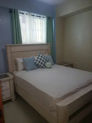 a bedroom with a large white bed with blue pillows at Vamar Apartamentos in San Felipe de Puerto Plata