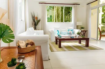 a living room with a couch and a table at Club Hemingway Amplio Apartamento en la Playa de Juan Dolio in Los Corrales