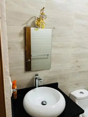 a bathroom with a sink and a mirror and a toilet at El Rincon Soleado in San Felipe de Puerto Plata