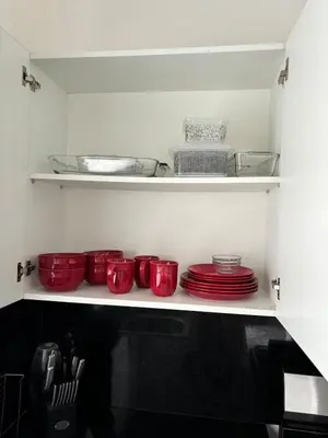 a shelf with red bowls and plates in a kitchen at El Rincon Soleado in San Felipe de Puerto Plata