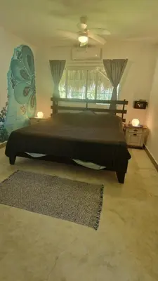 a bedroom with a large bed and a ceiling fan at Gecko Azul, Las Galeras in Las Galeras
