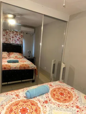 a bedroom with two beds and a large mirror at La Romana Caleta Apartment in La Romana
