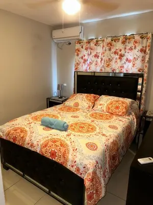 a bedroom with a large bed with a blanket at La Romana Caleta Apartment in La Romana