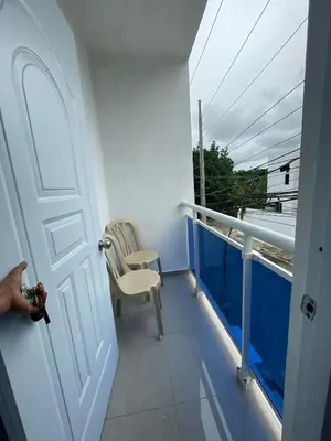a balcony with a white door and a chair at Apartamento acogedor a 5 minutos de la playa in San Felipe de Puerto Plata