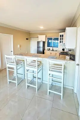 a kitchen with white chairs and a counter top at Itzayana 1 in Las Terrenas