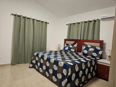 a bedroom with a bed and green curtains at Villa Jardín Tropical 2 in Las Galeras