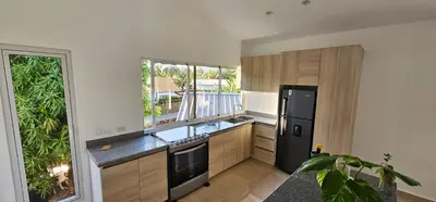 a kitchen with a black refrigerator and wooden cabinets at Villa Jardín Tropical 2 in Las Galeras
