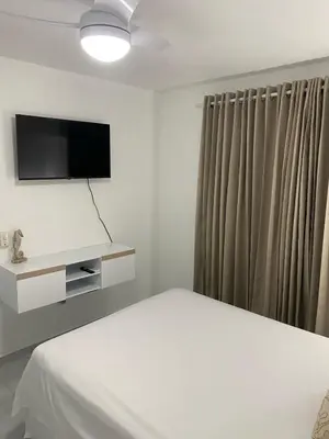 a bedroom with a bed and a flat screen tv at Apartamento en el Batey de Sosua in Sosúa