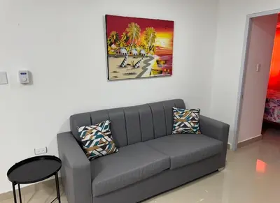 a living room with a couch and a painting on the wall at Elida Oceanfront Rentals in Sampiño